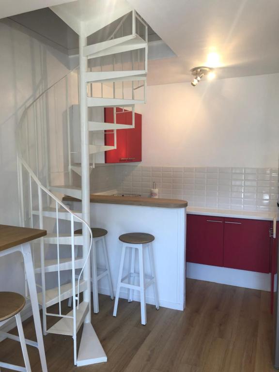une cuisine avec des placards rouges et une étagère blanche dans l'établissement Duplex centre ville 200m de la plage, à Dinard