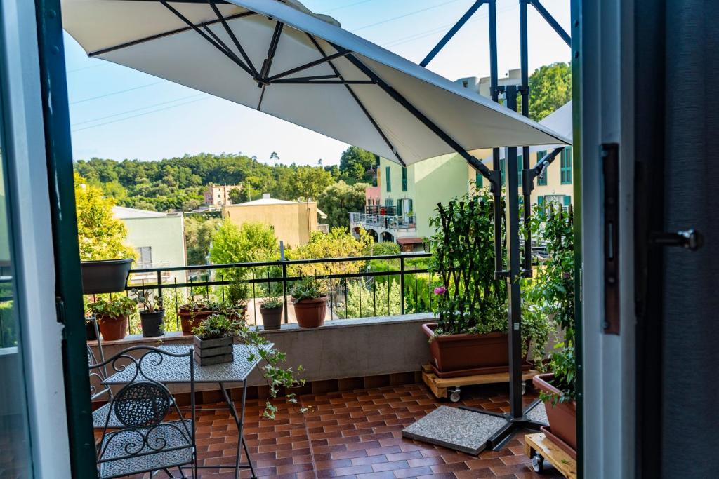 einen Balkon mit einem Tisch und einem Sonnenschirm in der Unterkunft Tui Beds in Arenzano