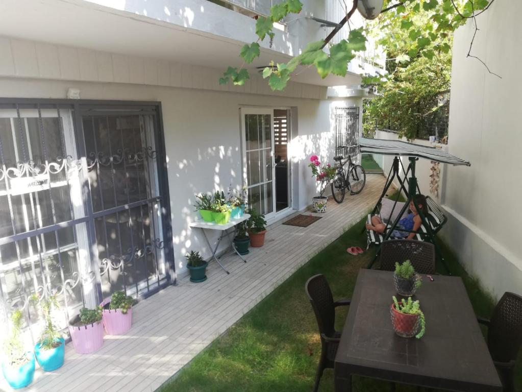 eine Terrasse mit Tischen und Topfpflanzen auf einem Haus in der Unterkunft İde Beach Home in Marmaris