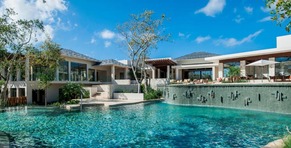 an exterior view of a house with a swimming pool at Fairmont Heritage Place Mayakoba in Playa del Carmen