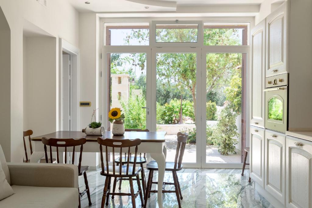 Una cocina y un comedor con mesa y sillas. en garden suite in Villa Mariella, en Ostuni