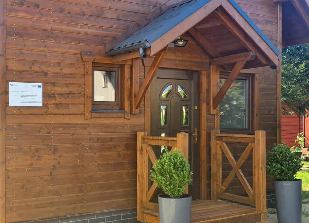 una casa de perros de madera con puerta de madera en Stepnicka Keja, en Stepnica