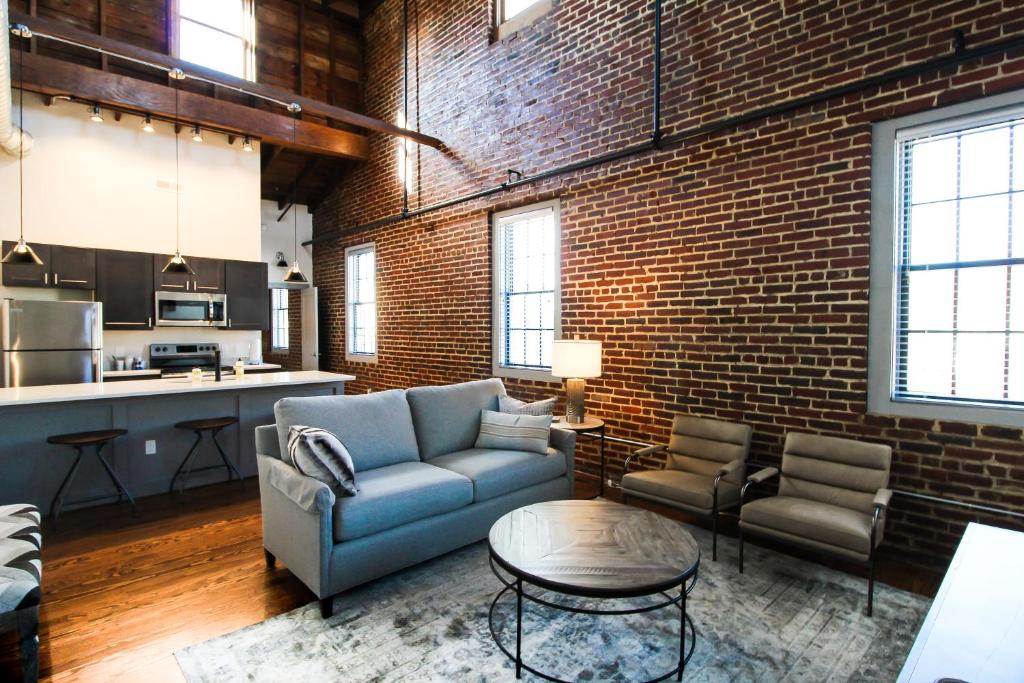 uma sala de estar com um sofá e uma parede de tijolos em The Lofts at Downtown Salem em Salem