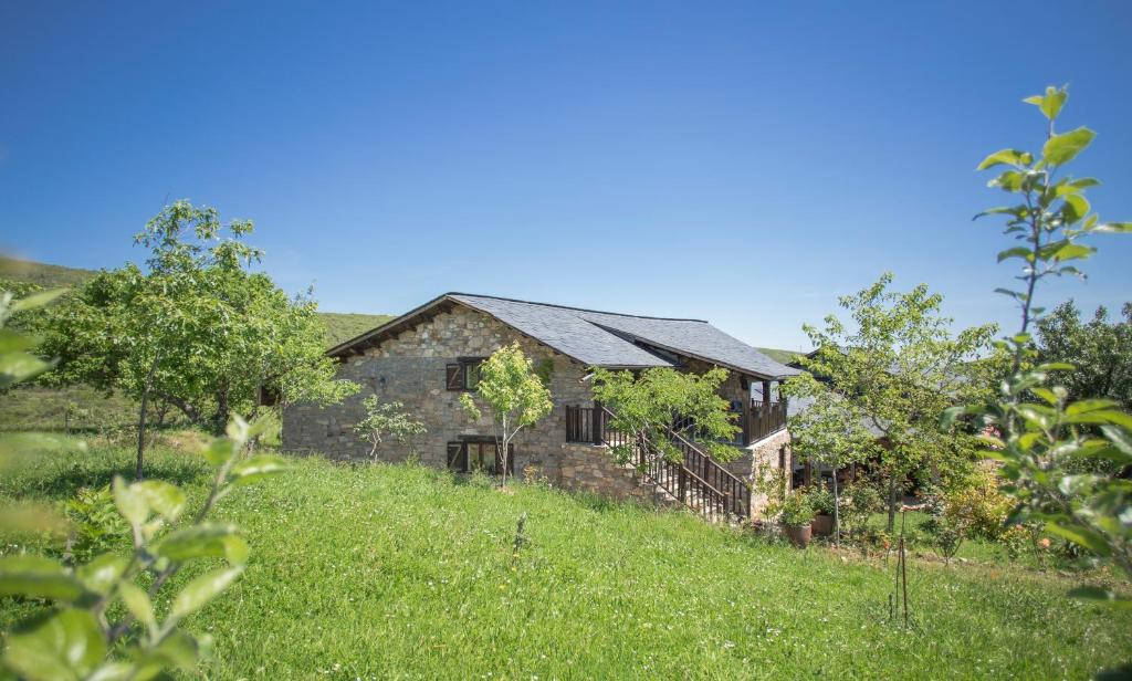 ein altes Steinhaus auf einem Grasfeld in der Unterkunft Rural Médulas Viviendas de uso turistico 1 y 2 y Casas rurales 3 y 4 in Las Médulas