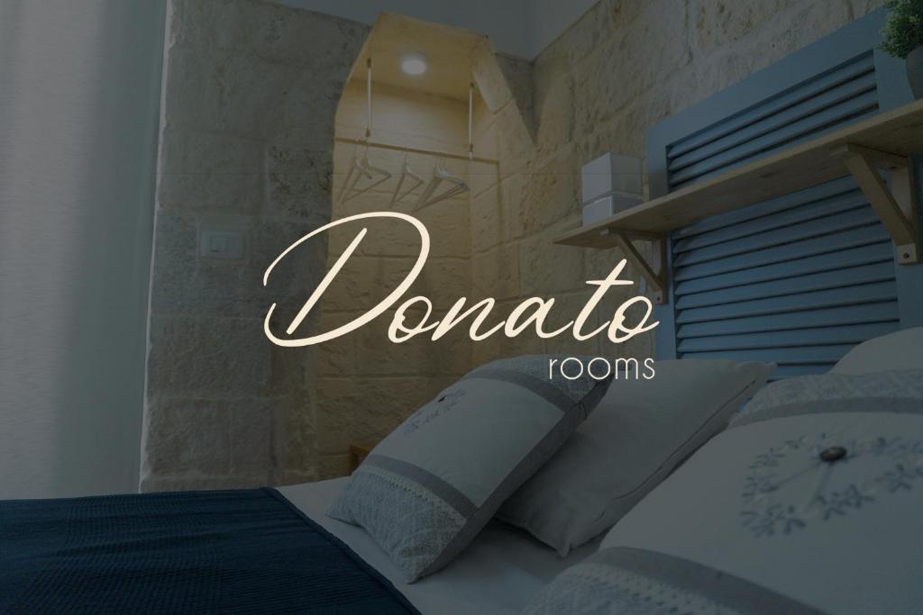 un dormitorio con un cartel que lee habitaciones donadas en Donato Rooms en Trani