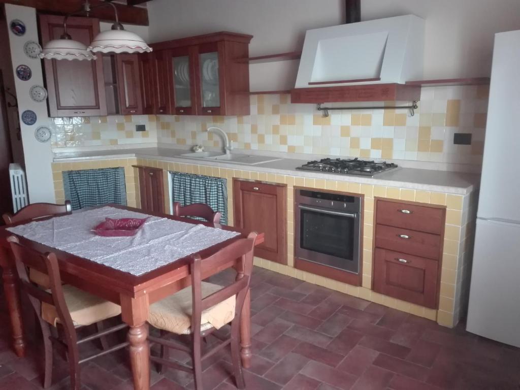 a kitchen with a table and a stove top oven at La Casina in Asciano
