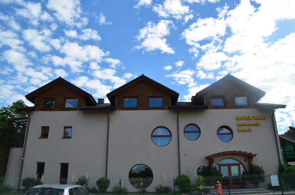 a building with two roofs on top of it at Hotel Tenis in Chrząstowice