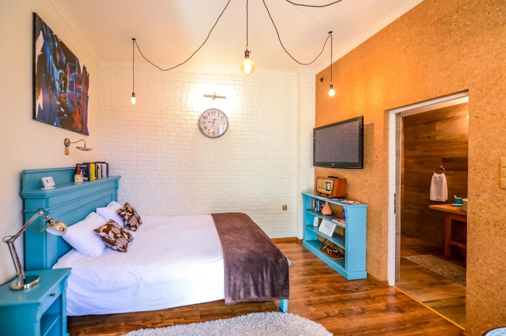 1 dormitorio con 1 cama azul y TV en ATRIUM 24 Suite, en Sighişoara