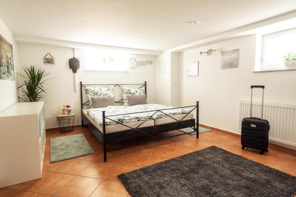 ein Schlafzimmer mit einem Bett und einem Koffer darin in der Unterkunft Ferienwohnung Casa Sophia in Seeheim-Jugenheim
