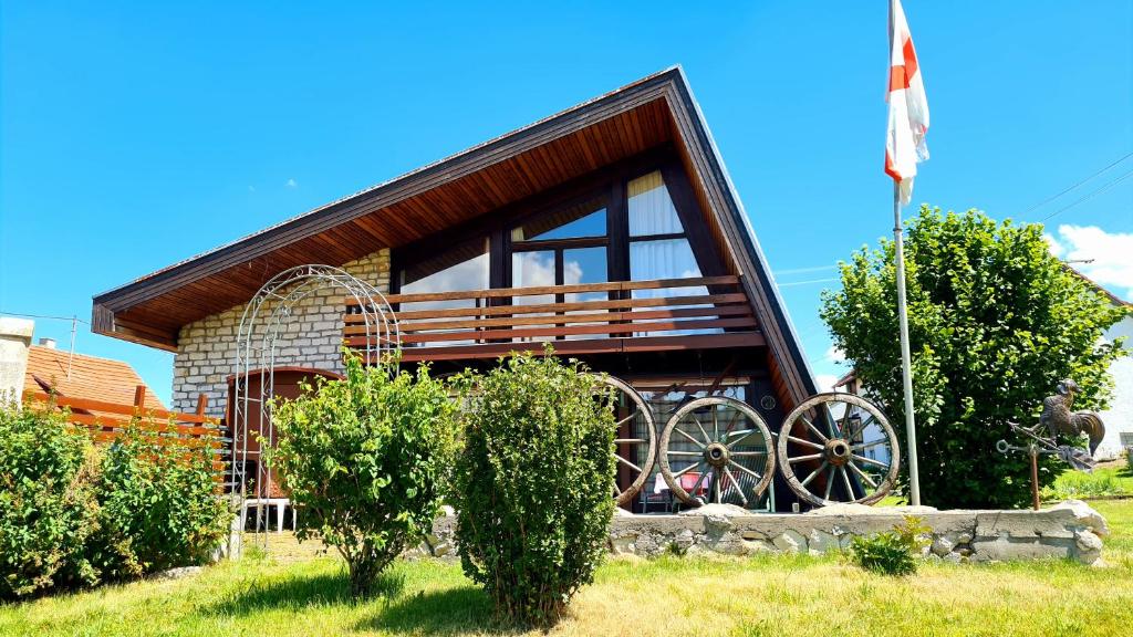 a house with a large window and a flag at Ferienhaus Waldblick in Sonnenbühl