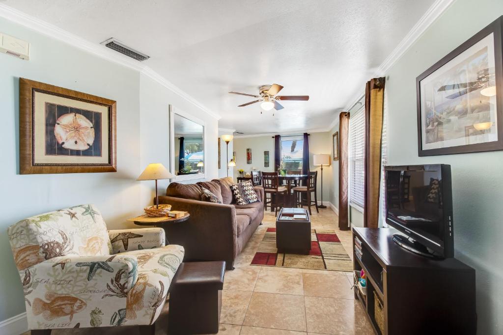 a living room with a couch and a tv at Gulf View Cottage #3 in Bradenton Beach