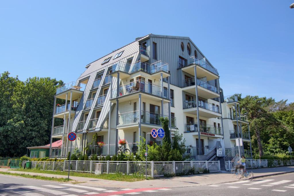 een hoog wit gebouw aan de kant van een straat bij Apartament Bursztyn 2 in Świnoujście