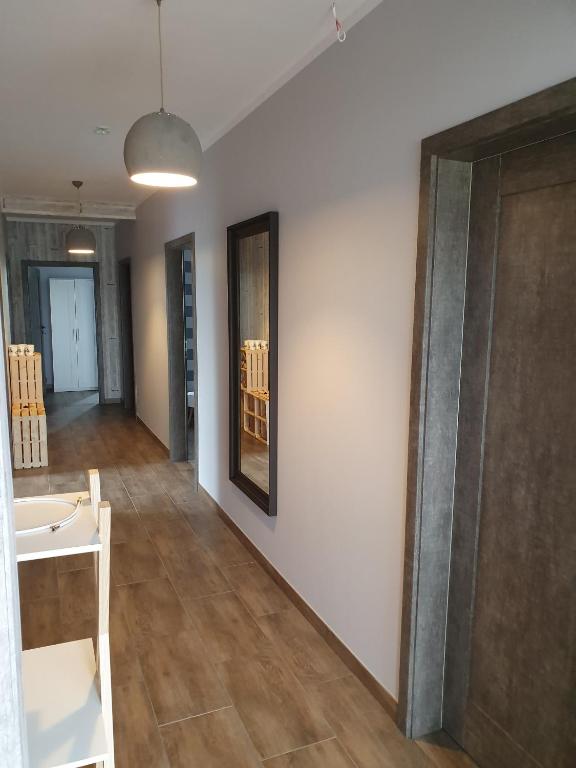 Pokój z białą ścianą i drewnianą podłogą w obiekcie Noclegi Róża Wiatrów w mieście Górowo Iławeckie