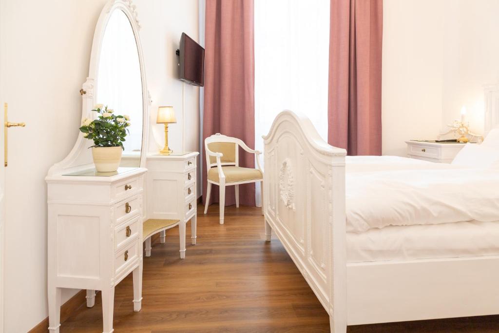 a white bedroom with a white bed and a mirror at Heritage Boutique Apartments Bad Ischl in Bad Ischl