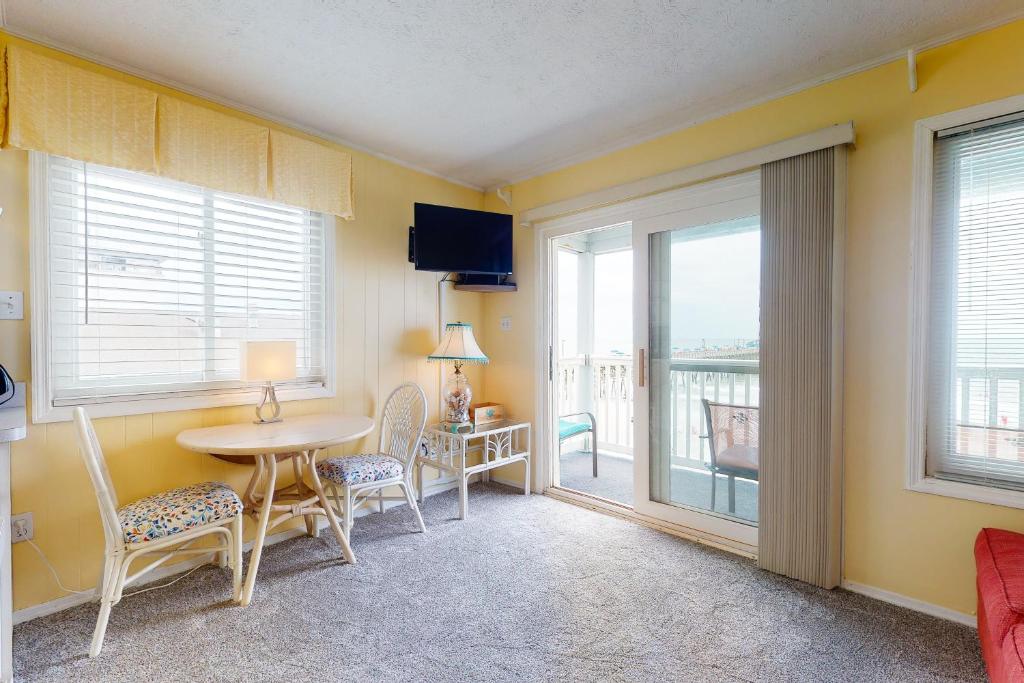 a dining room with a table and chairs and a window at Beachfront Blessing in Myrtle Beach