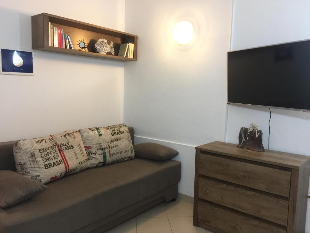 a living room with a couch and a flat screen tv at Apartma Izola in Izola
