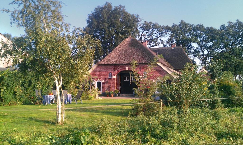 una casa de ladrillo rojo con techo de paja en De Bolderie, en Markelo