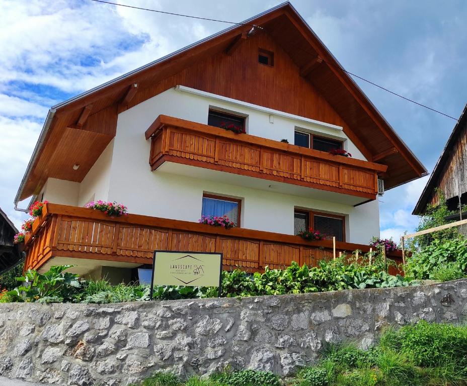 une maison avec un balcon au-dessus d'un mur dans l'établissement Apartment Landscape - new modern apartment near Bled, à Zgornje Gorje