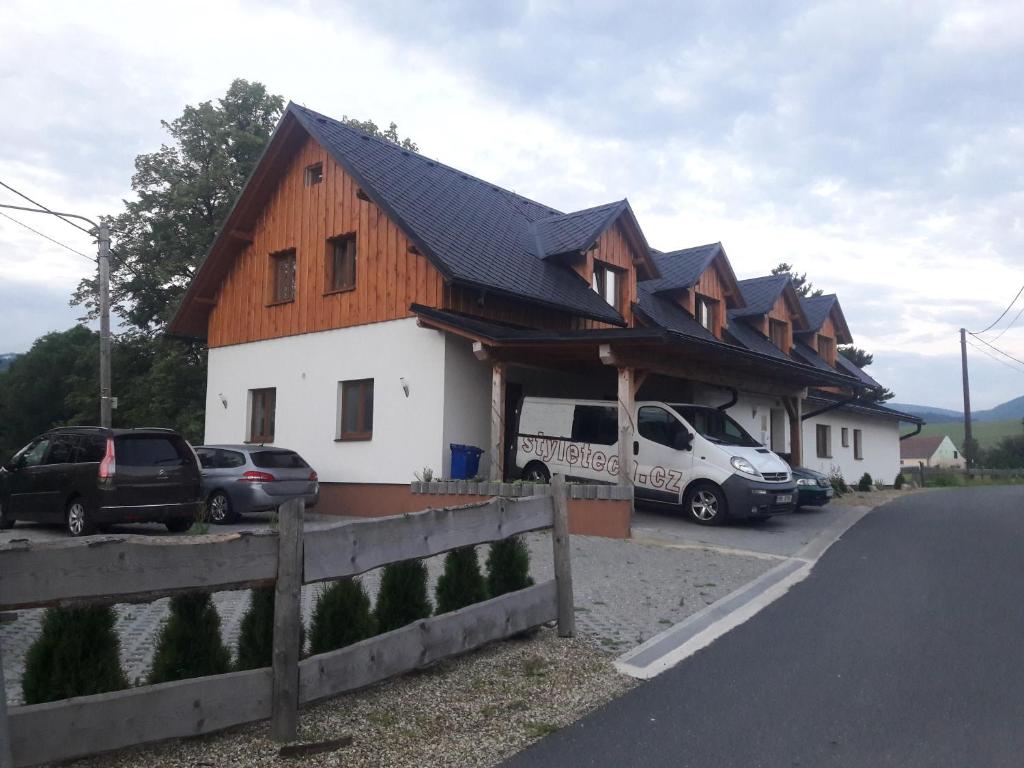 a house with cars parked in front of it at Chata Tánička in Jeseník