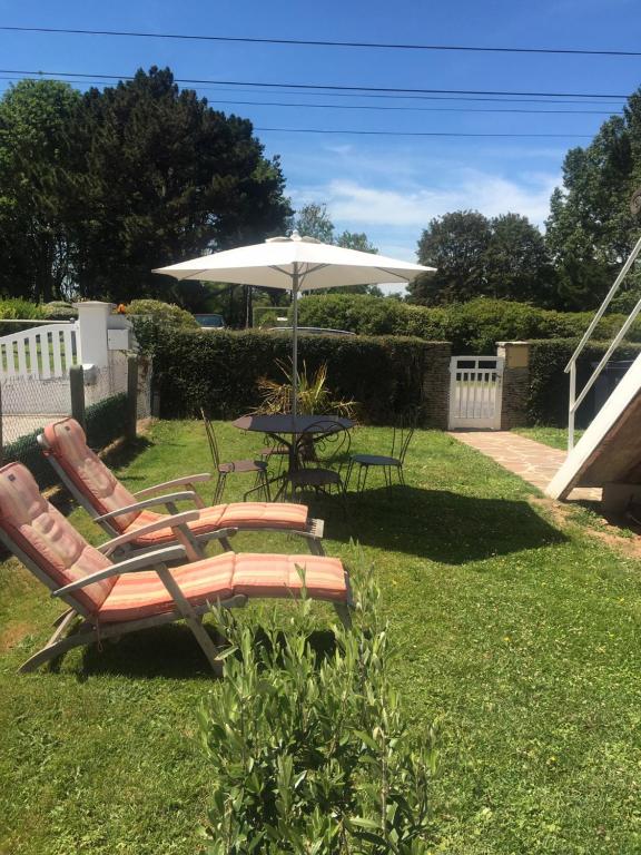 - deux chaises et un parasol dans la cour dans l'établissement Chez Jacques et Annick, à Grandcamp-Maisy