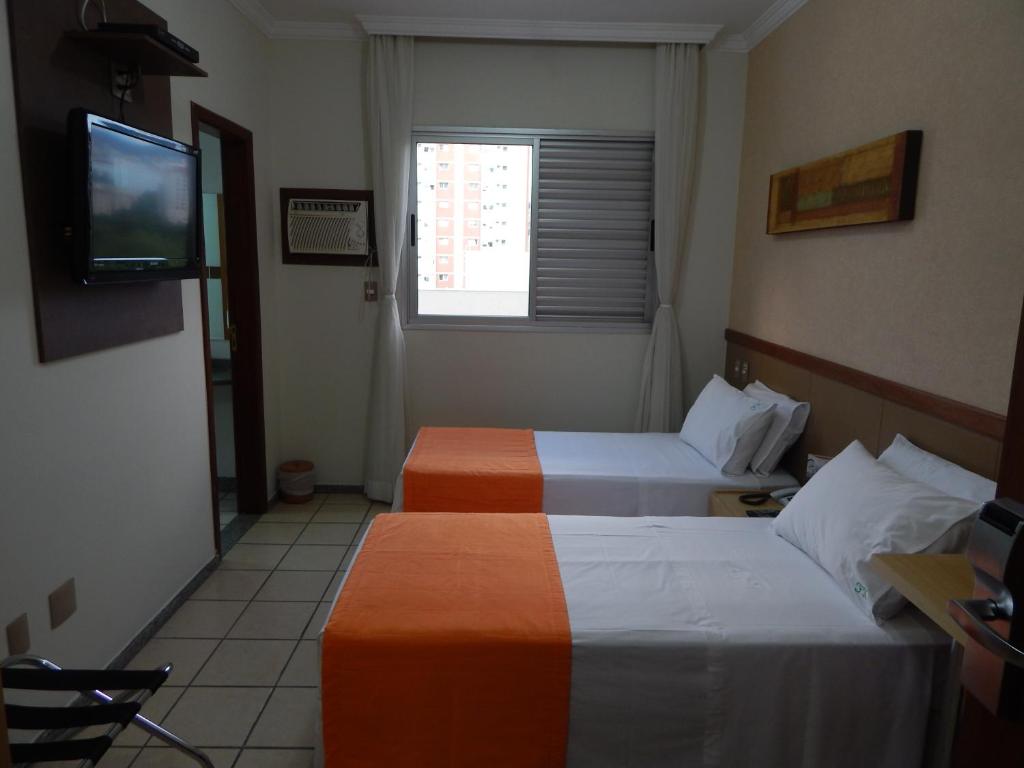 a hotel room with a bed and a television at Frimas Hotel in Belo Horizonte