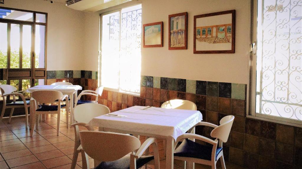 a restaurant with tables and chairs in a room at Hotel Ayamontino in Punta Umbría