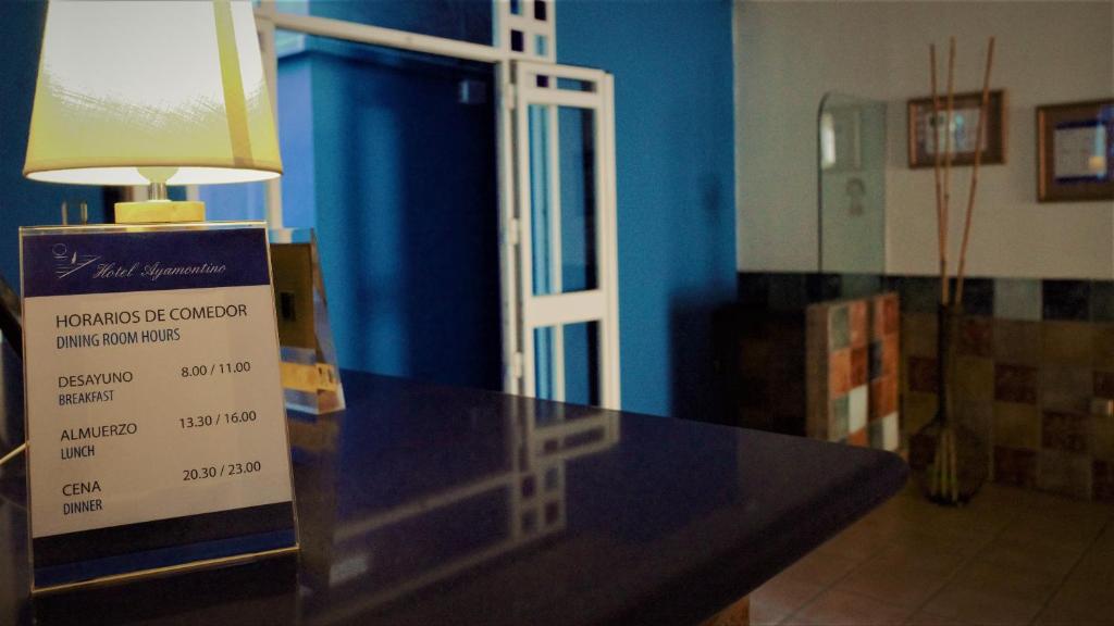 a table with a sign on it in a room at Hotel Ayamontino in Punta Umbría