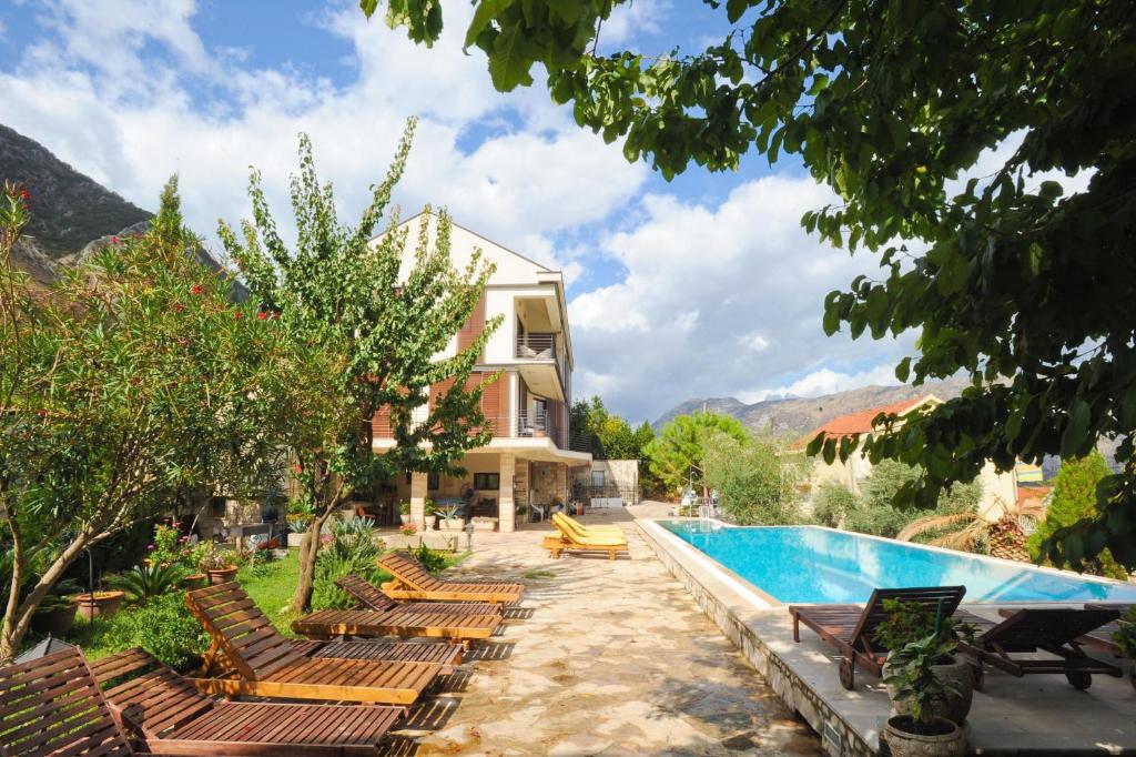 a resort with a swimming pool and lounge chairs at Apartments Feral in Kotor