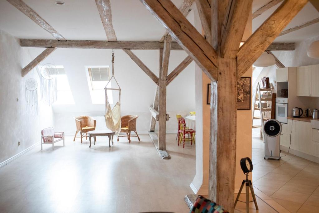 un soggiorno con soffitti in legno, tavolo e sedie. di Apartament Ratuszowa a Lidzbark Warmiński