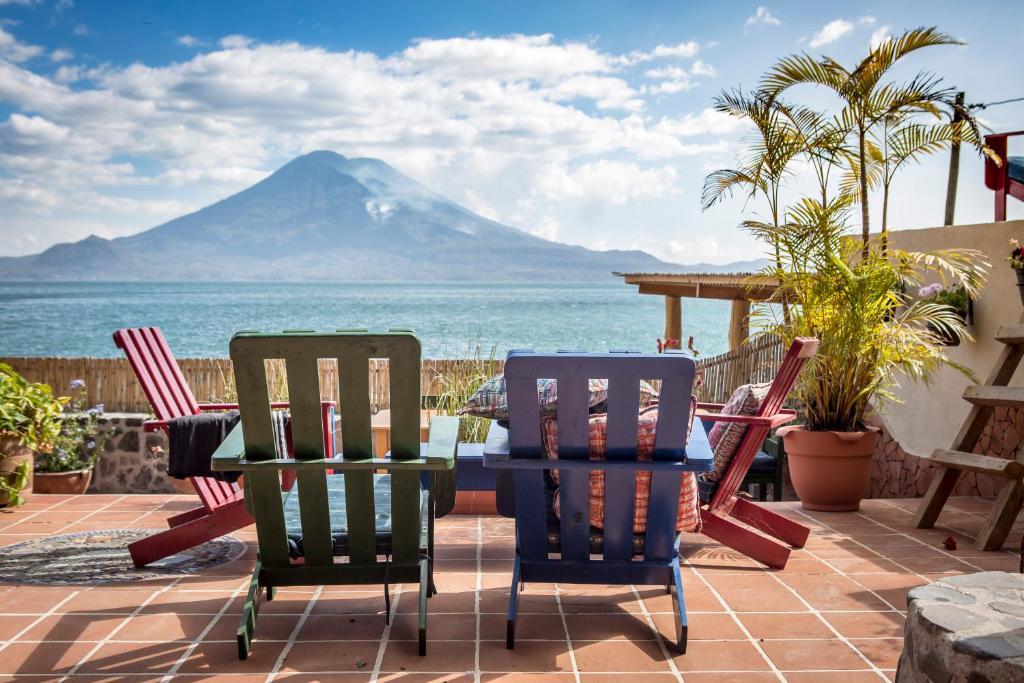 a patio with chairs and a table with a view of a mountain at La Iguana Perdida in Santa Cruz La Laguna