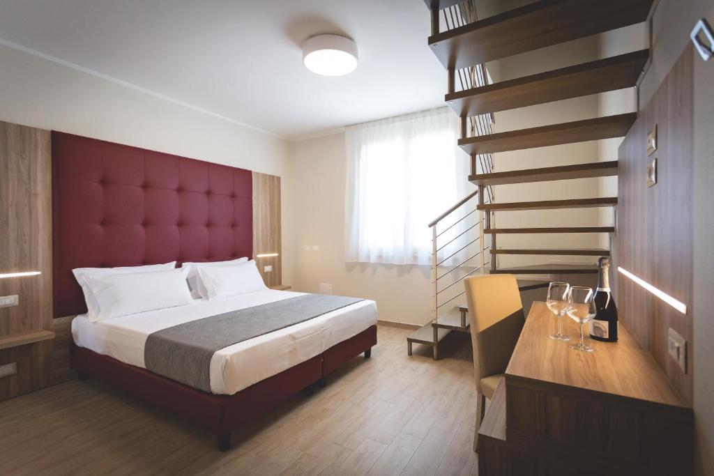 a hotel room with a large bed and a large window at Hotel Residence Vallecorsa in Rosignano Marittimo