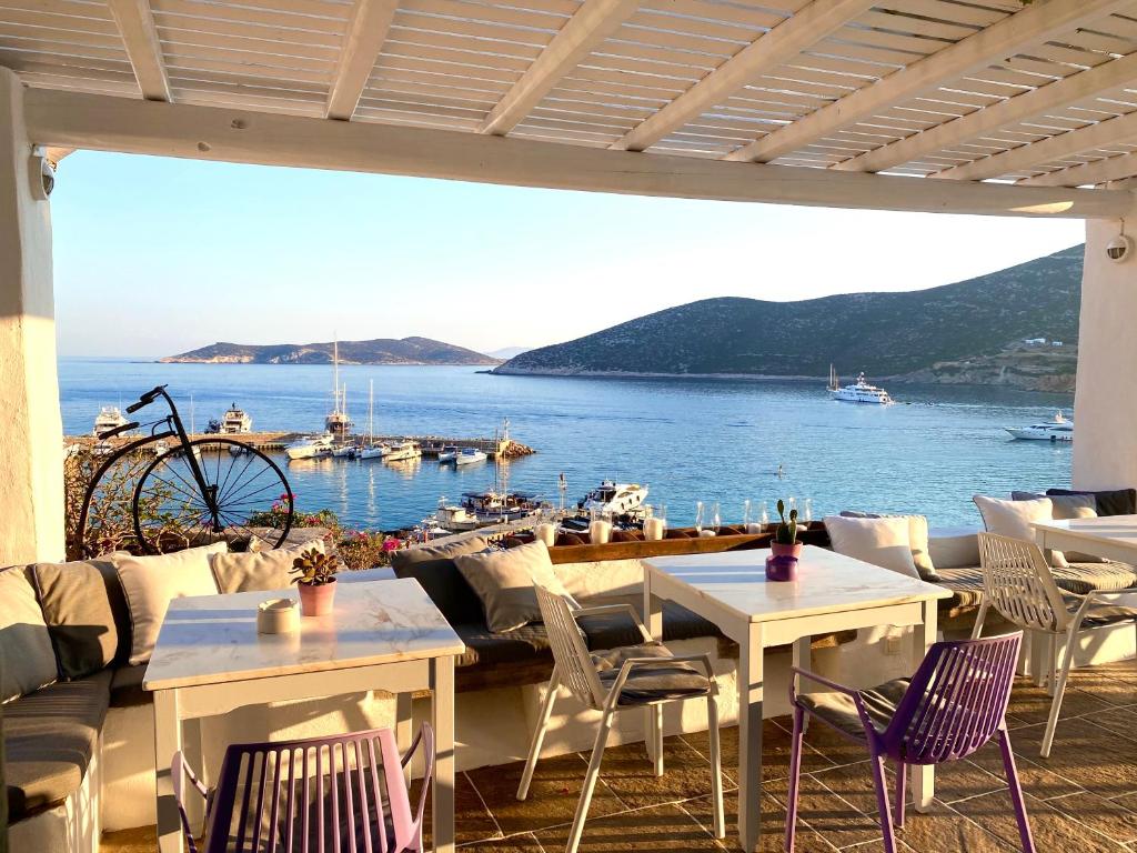 a restaurant with tables and chairs and a view of the water at Niriedes Hotel in Platis Yialos Sifnos