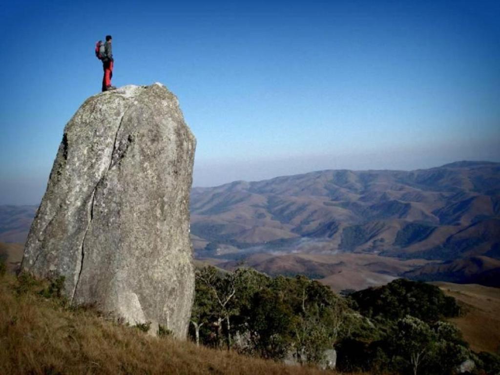 a person standing on top of a large rock at Pousada Dona Maria in Areias