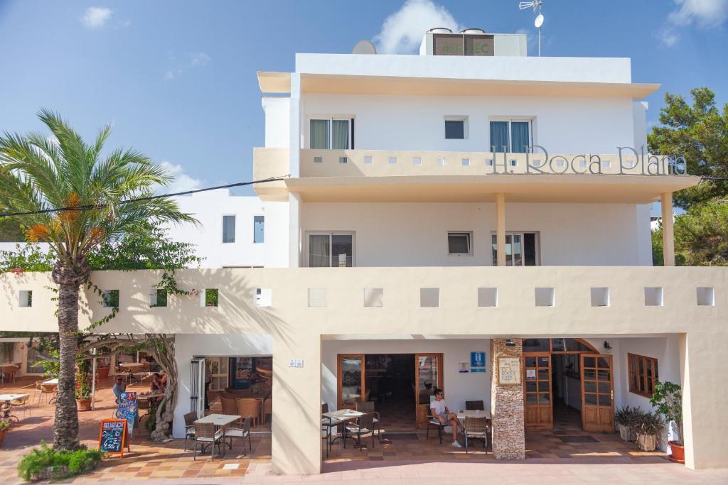 a white building with a sign that readsoca drink at Hotel Roca Plana in Es Pujols