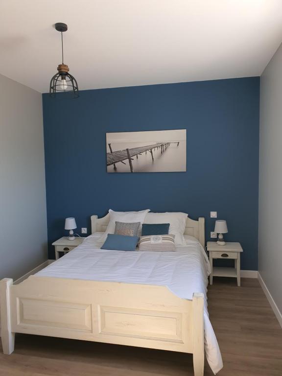 a bedroom with a large bed with blue walls at LES 5 ESCALES in Parthenay