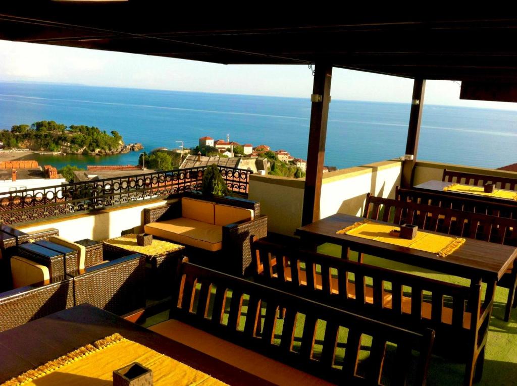 un restaurante con mesas y sillas en un balcón en Apartments Tati, en Ulcinj