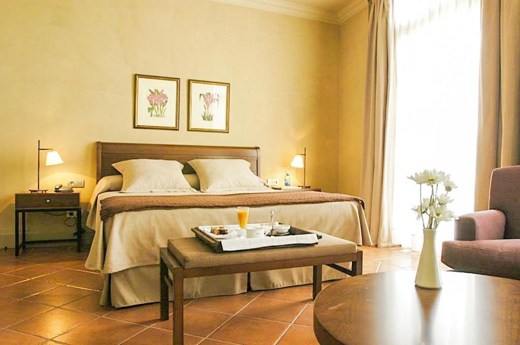 a hotel room with a bed and a coffee table at Bremon Boutique Hotel by Duquessa Hotel Collection in Cardona