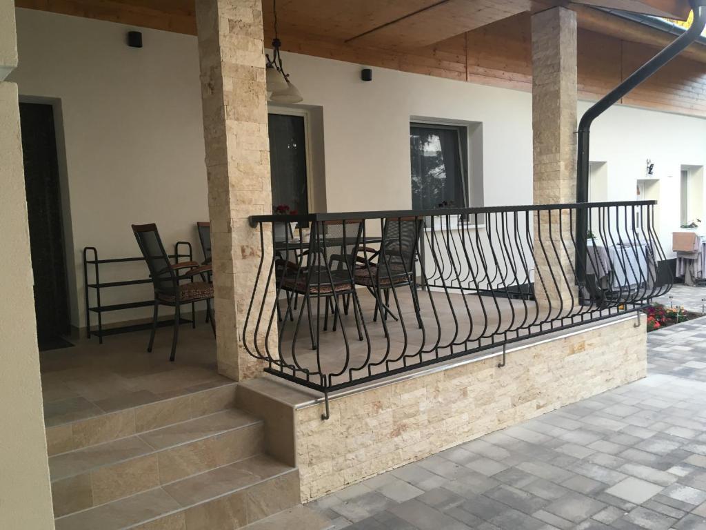 einen Balkon eines Hauses mit einem Tisch und Stühlen in der Unterkunft Balatonkenesei Vendégház in Balatonkenese