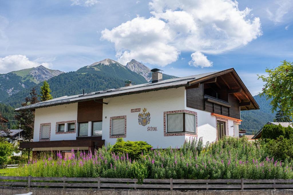 a white house with mountains in the background at Landhaus Scherl in Seefeld in Tirol