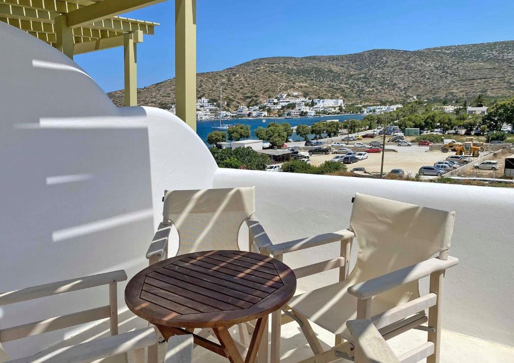 two chairs on a balcony with a view of a town at Diasino Apartments and Car Rental in Katapola
