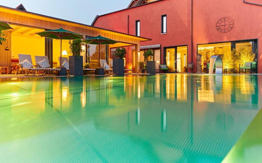 a swimming pool with umbrellas next to a building at Landhotel Krone in Heitersheim