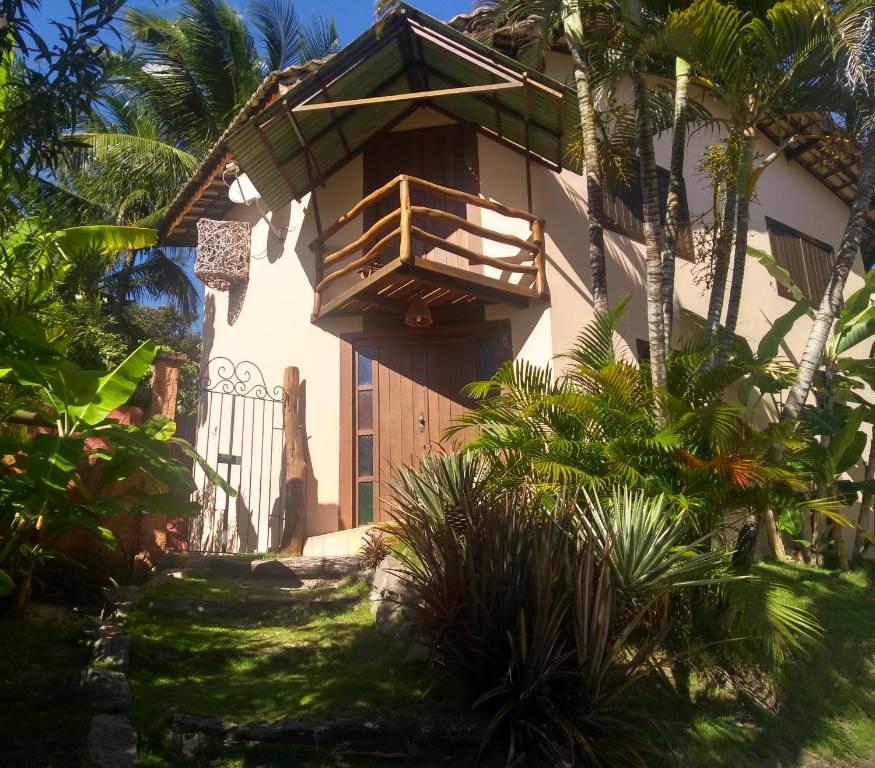 a house with a balcony on the side of it at Chalés Beijupirá in Pipa