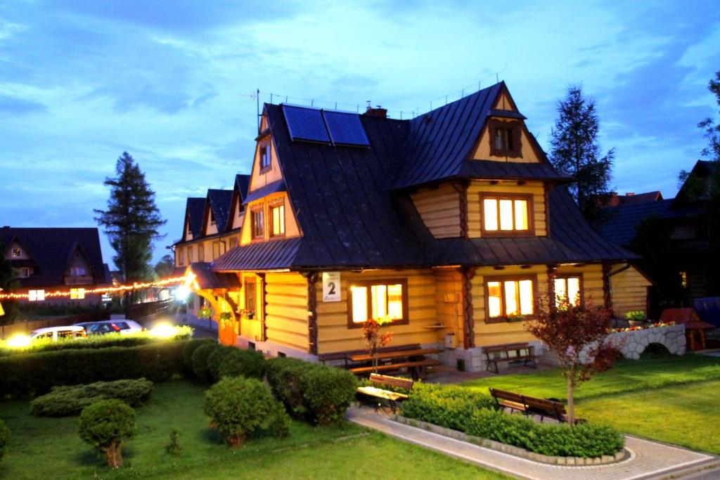 a large wooden house with its lights on at Willa Borowik in Zakopane