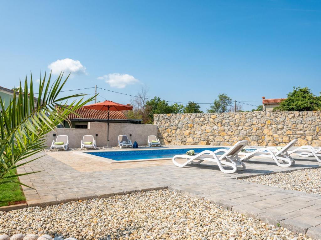 una piscina con 2 sillas y una sombrilla en Tranquil Holiday Home in Labin with Private Swimming Pool, en Labin