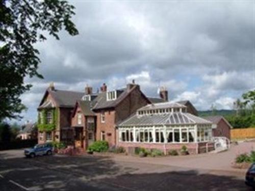 a large house with a greenhouse in front of it at Inchture Hotel in Dundee