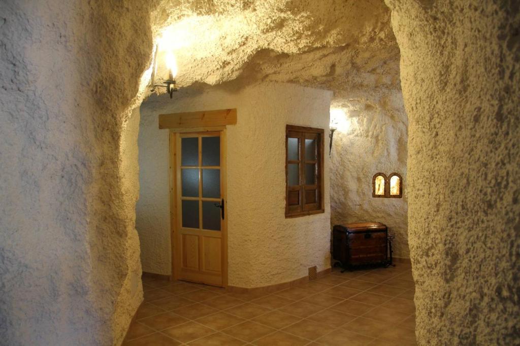 un couloir avec une porte dans un bâtiment en pierre dans l'établissement CUEVAS AL ANDALUS - Solea, à Orce