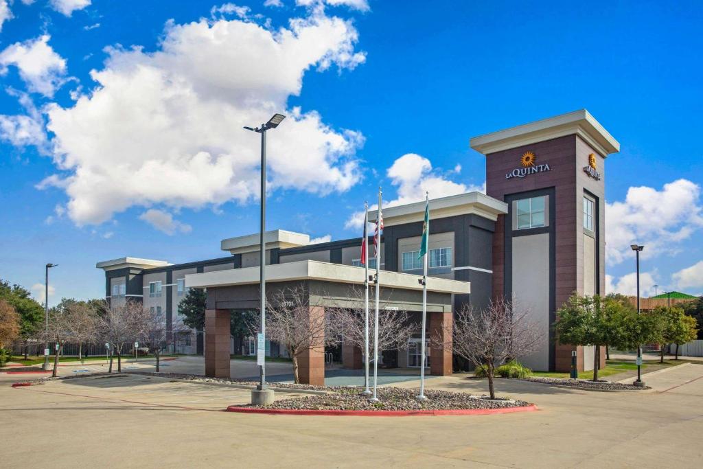 een gebouw met een vlag ervoor bij La Quinta by Wyndham Austin NW/Lakeline Mall in Cedar Park