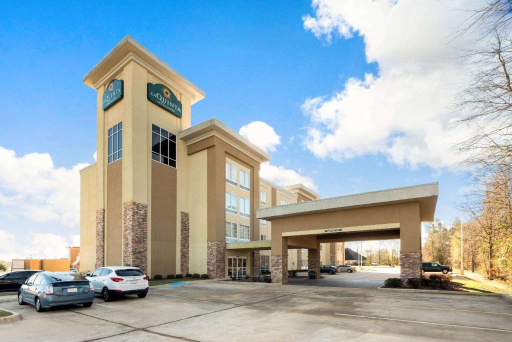 a large building with a clock tower in a parking lot at La Quinta by Wyndham West Monroe in West Monroe