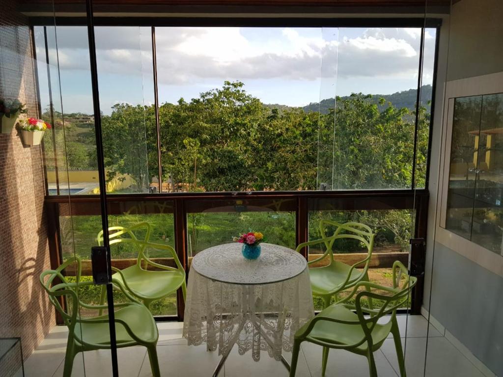 een kamer met een tafel en stoelen en een groot raam bij apartamento em serra negra - bezerros in Bezerros