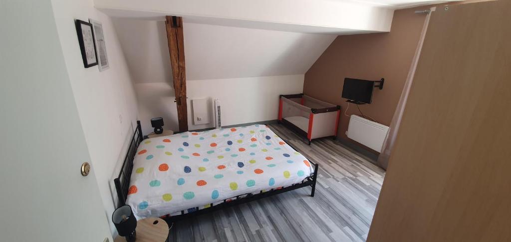 sypialnia z łóżkiem z prześcieradłem z kropek w obiekcie Gîte Savigny en Sancerre w mieście Savigny-en-Sancerre